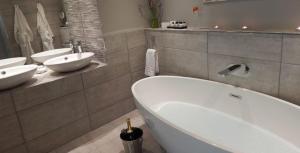 a bathroom with two sinks and a bath tub at Bluebell Lodge in Errol