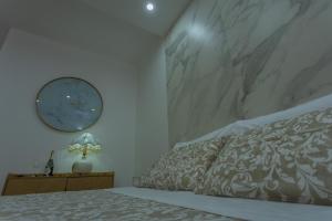 a bedroom with a bed with a clock on the wall at Rooms 2,6 in Terlizzi