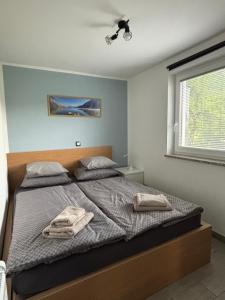 a bedroom with a bed with two towels on it at Apartments Kolačko in Bohinj
