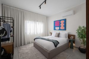 a bedroom with a large bed and a window at Livingville East Aparthotel in Cairo +50 photos