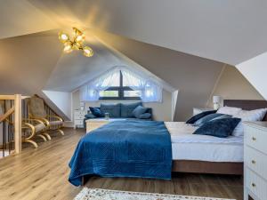 a bedroom with a large bed with a blue comforter at Złota Przystań w Bałtyckiej Oazie in Jastrzębia Góra +22 photos