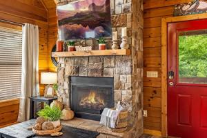 une cheminée dans une cabane en rondins avec une porte rouge dans l'établissement View-Location-Hot Tub-2 Fireplaces-Jacuzzi-Arcade, à Sevierville