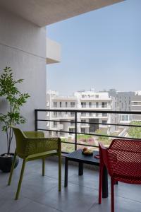 a balcony with a table and chairs and a view of a building at Livingville East Aparthotel in Cairo
