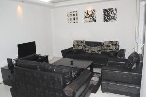 a living room with black leather furniture and a tv at Marija Apartman in Bitola