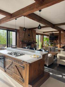 a kitchen with a stove and a living room at Przestrzeń Mazury in Bagienice