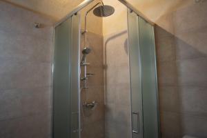 una doccia con una porta in vetro in un bagno di Villa Fontana a Casa Boscarelli Altre 24 foto