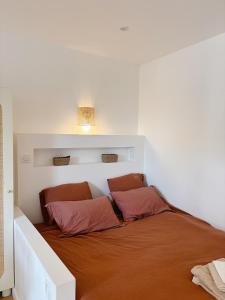 a bedroom with a bed with two pillows on it at Studio cosy avec extérieur - Lyon Eurexpo Stadium in Chassieu