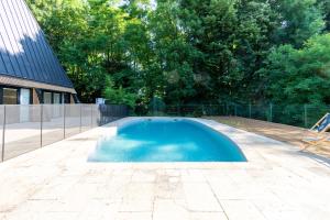 a swimming pool in a yard next to a house at Hôtel La Cachette de Nina- Madame rêve - Saint-Girons in Saint-Girons