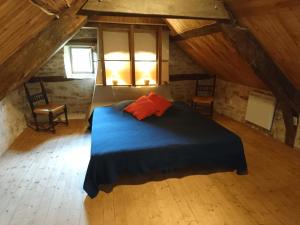 a bedroom with a blue bed in a attic at La Combe aux étoiles in Villefranche-de-Rouergue
