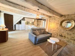 a living room with a couch and tables and a kitchen at La Combe aux étoiles in Villefranche-de-Rouergue