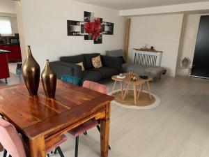 a living room with a table and a couch at Maison élégance in Alès