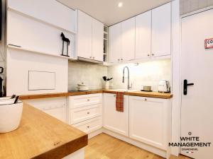 a white kitchen with white cabinets and a sink at Résidence Solaret Des Brigues - Superbe duplex dans le quartier des Brigues MAE-5864 in Courchevel +8 photos