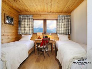 a bedroom with two beds and a table with a desk at Résidence Solaret Des Brigues - Superbe duplex dans le quartier des Brigues MAE-5864 in Courchevel