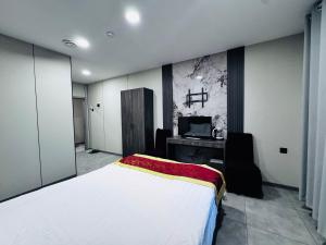 um quarto com uma cama, uma escrivaninha e uma TV em Lofty Hotel em Ulaanbaatar