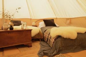 a bedroom with two beds in a tent at Mallard - 5m Luxury Bell Tent at Tregonetha Lake - Tylda Tents in Saint Columb Major