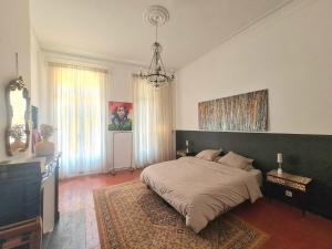 a bedroom with a large bed and a chandelier at chambre d'hôtes hyper central in Perpignan