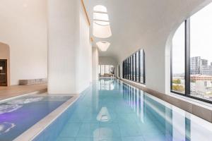 a large swimming pool in a building with windows at Aspire Urban Retreat in the Heart of CBD in Melbourne