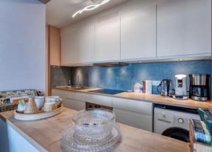 a kitchen with white cabinets and a counter top at Studio Zeevonk Panoramic Sea View in Wenduine