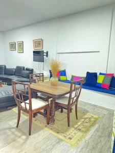 a dining room with a table and chairs and a couch at RDC de villa Marsa cité tabbak in La Marsa +5 photos