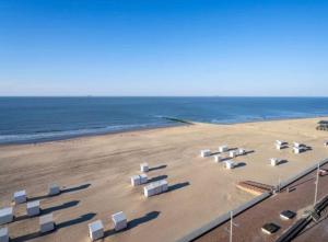 a beach with several white structures on the sand at Studio Zeevonk Panoramic Sea View in Wenduine