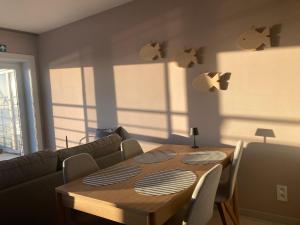 a dining room with a table and a couch at Studio Zeevonk Panoramic Sea View in Wenduine