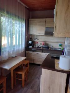 a kitchen with wooden cabinets and a table and a counter at Casa din Dâmb in Breb