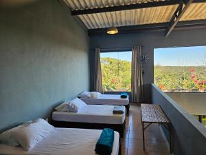 una habitación con tres camas y una ventana en Casa completa linda vista, en Chapada dos Guimarães