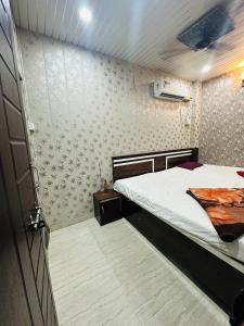 a small bedroom with a bed and a wall at Mahadev Residency in Varanasi