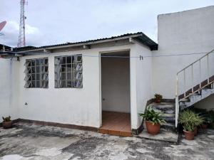 a white house with a door and some plants at lindo apartamento in Guatemala
