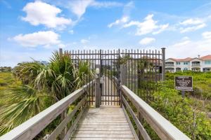 a gate leading to a walkway leading to a house at Hibiscus By the Sea - Stay for 5 in Saint Augustine