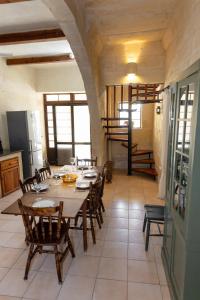 Un comedor con una mesa y sillas de madera. en Tal-Masklu farmhouse, en Għarb