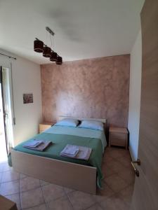 a bedroom with a bed with a green comforter at Onda Blu in Marina di Vasto +1 photo