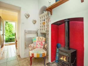 a room with a chair and a wood stove at Lynwood in Boscastle +21 photos