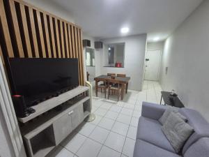 a living room with a tv and a blue couch at Apartamento aconchegante e bem localizado in Belo Horizonte