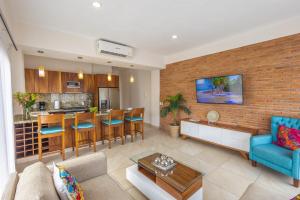 ein Wohnzimmer und eine Küche mit einer Ziegelwand in der Unterkunft Beautiful view in Gringo Gulch 202 in Puerto Vallarta