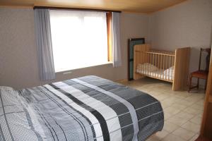 a bedroom with a bed and a crib and a window at Hof Ter Hagen in Lokeren