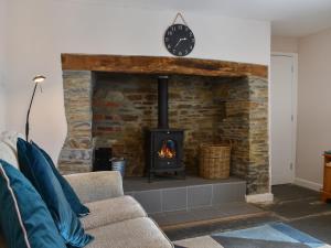 a living room with a brick fireplace with a stove at Uk47757 - Rose Cottage in Launceston