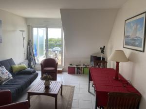 a living room with a couch and a table at Appartement 2 personnes - Face plage Valentin - FR-1-843-24 in Le Croisic