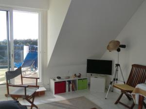 a living room with a flat screen tv and chairs at Appartement 2 personnes - Face plage Valentin - FR-1-843-24 in Le Croisic