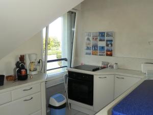 a kitchen with white cabinets and a black stove top oven at Appartement 2 personnes - Face plage Valentin - FR-1-843-24 in Le Croisic