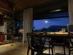 a dining room with a table and chairs and a window at A nossa casa da arvore in Cavalcante