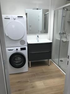 ein Badezimmer mit Waschmaschine und Waschbecken in der Unterkunft Maison traditionnelle en pierre - Penn'ti in Cancale