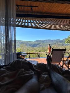 una persona sdraiata a letto che guarda fuori dalla finestra verso un panorama di A nossa casa da arvore a Cavalcante