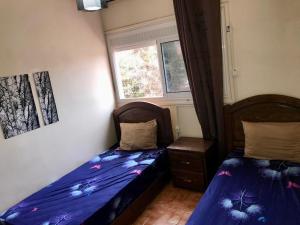 une chambre avec deux lits jumeaux et une fenêtre dans l'établissement Charming house in Imi Ouddar, à Agadir nʼ Aït Sa