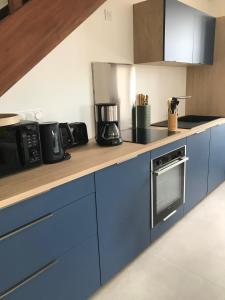 eine Küche mit blauen Schränken und einer Arbeitsplatte in der Unterkunft Maison traditionnelle en pierre - Penn'ti in Cancale
