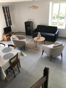 ein Wohnzimmer mit Sofa, Stühlen und einem Tisch in der Unterkunft Maison traditionnelle en pierre - Penn'ti in Cancale