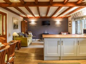 a kitchen with white cabinets and a living room at Trough Cottage - Uk48424 in Holmfirth