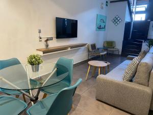 un salon avec un canapé, une table et une télévision dans l'établissement Apartamento La Machacona TENERIAS, à Cáceres
