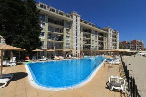 een groot hotel met een groot zwembad naast een strand bij Първа линия Апартаменти in Pomorie