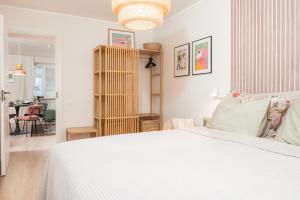 Un dormitorio con una cama blanca y un comedor. en Apartement Nikolai, en Pärnu